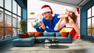 Young couple celebrating christmas at home Wall mural