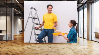 Young couple painting wall at home Wall mural