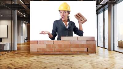 Young female builder near brick wall Wall mural