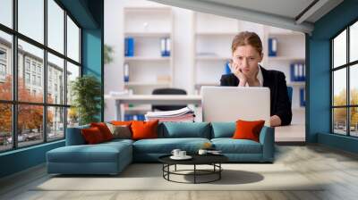 Young female employee working in the office Wall mural