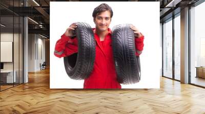 Young garage worker with tyre isolated on white Wall mural