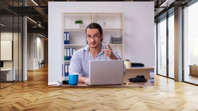 Young male bookkeeper working in the office Wall mural