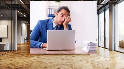 Young male businessman working in the office Wall mural