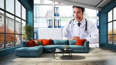 Young male doctor in telehealth concept Wall mural