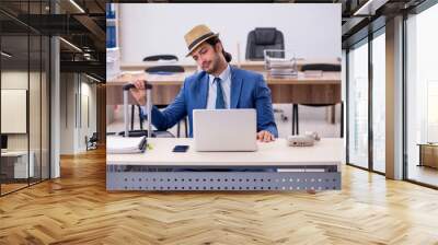 Young male employee preparing for trip in the office Wall mural