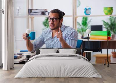 Young male employee working in the office Wall mural