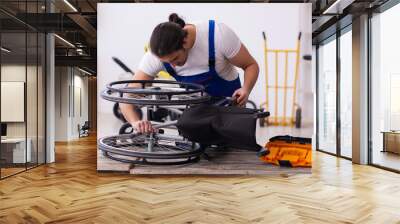 young male repairer repairing wheel-chair indoors Wall mural