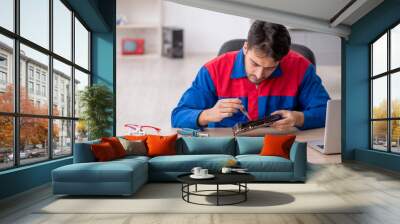 Young male repairman repairing computer Wall mural