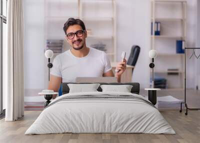 Young male student employee at workplace Wall mural