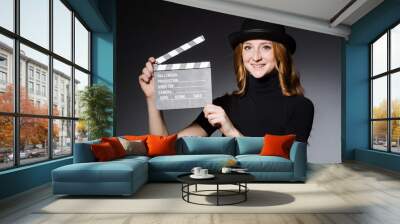 Young redhead girl in hat with movie board against grey backgrou Wall mural