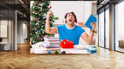 Young student with book at Christmas eve  Wall mural