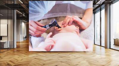 doctor looks at the ear with an otoscope Wall mural