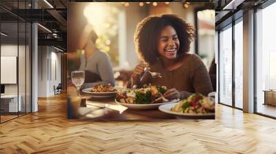 Cheerful African American lady having Thanksgiving lunch with her family and serving serving of mixed greens at feasting table. Wall mural