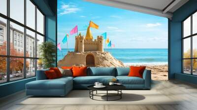 A vibrant sand castle adorns a sun-kissed beach, its colorful flags fluttering against the backdrop of a vast ocean. This captivating panorama captures the essence of relaxation  Wall mural