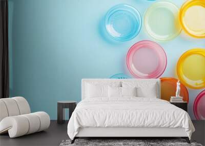 Flat lay image of colorful plastic frisbees on a light blue background, leaving ample space for text or branding.  Wall mural