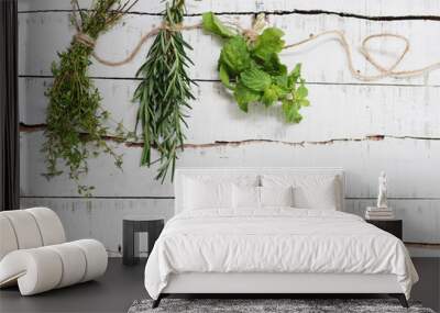 Thyme, rosemary and mint hanging on twine over white wood Wall mural