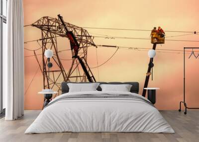 Two workers in telescopic boom lift repair power line. Sunset light. Wall mural