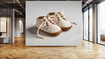 Pair of baby shoes tied together on a white background Wall mural