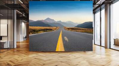 an asphalt road with a yellow dividing strip leads into the distance mountain landscape in the background Wall mural