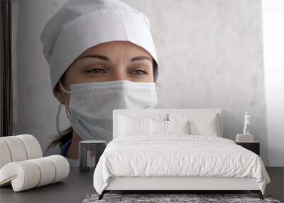 Female doctor or nurse in uniform and mask feeling down very tired after receive patients in hospital. Woman looking straight at camera. Hard work, medical, epidemic concept Wall mural