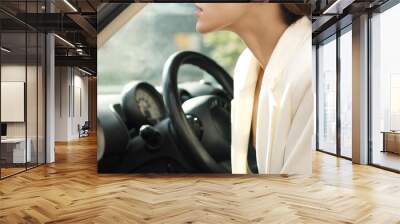 Beautiful girl sitting behind wheel inside car Wall mural