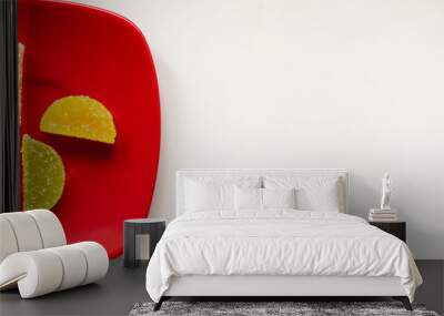 Two Sugar candies on a red plate Wall mural