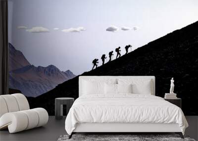 Five like-minded professional climbers hike towards the summit Wall mural