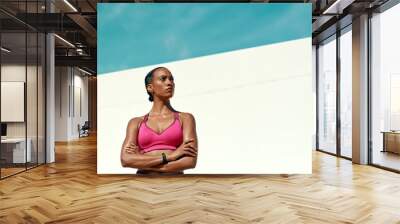 Sports, fitness and serious woman with blue sky, mockup at outdoor gym for health and wellness. Workout, exercise and confidence, fit athlete with focus space and healthy mindset for summer goals. Wall mural