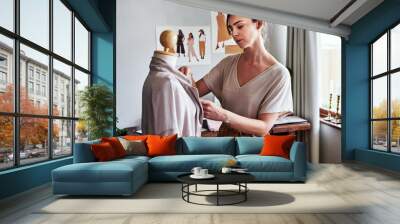 Fashion, design and woman with mannequin, focus and creative small business or clothing boutique. Art, creativity and tailor or designer with dress on doll for clothes in studio for textile start up. Wall mural