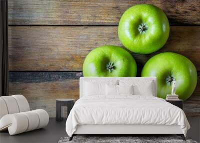 Verdant apples grace a wooden table, seen from above. Wall mural