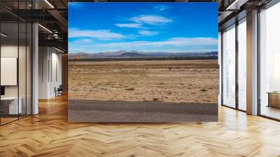 Arid landscape at international airport with an orange weather vane, mountains against blue sky in background, landing and takeoff runway, sunny winter day in La Paz, Baja California Sur Mexico Wall mural