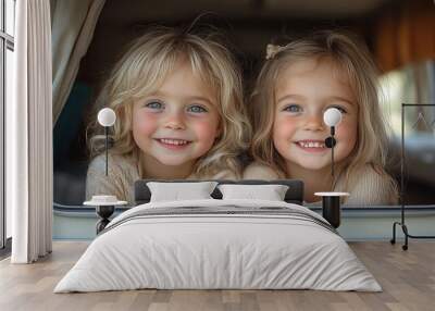 happy two little girls looking out of caravan and smiling to camera Wall mural