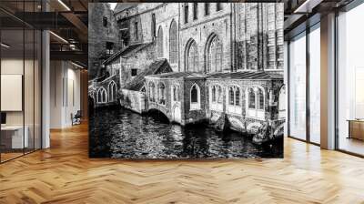 Medieval buildings on bank of the Dijver canal, brick walls, huge windows and enclosed terraces, calm water on a sightseeing day in province of West-Vlaanderen, Belgium. Black and white photography Wall mural