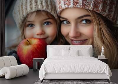 mother giving apple to her daughter in car Wall mural