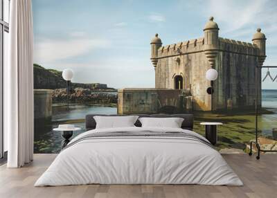 A historic coastal setting, dominated by a stone fort or tower with turrets Wall mural