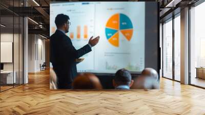 A businessman is presenting data and graphs to a group of people during a meeting. Wall mural