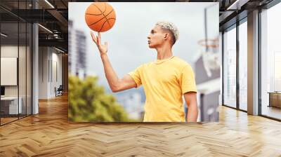 Sports, fitness and man spinning basketball on court outdoors before workout, exercise or practice. Basketball court, balance and young male player with ball on finger getting ready for training. Wall mural