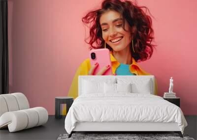 A young woman using her smartphone against a pastel background. Wall mural