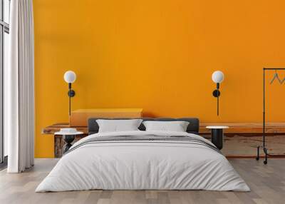 Book on wooden table with yellow orange wall background Wall mural