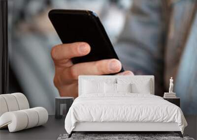 Close up of man hands holding smartphone. Watching him sms, messages, email in his cell phone cafe. Wall mural