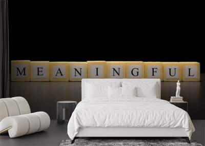 The word MEANINGFUL written on wooden cubes isolated on a black background Wall mural