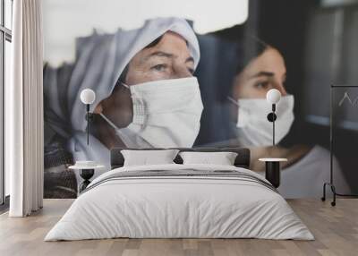 Portrait of senior woman and daughter with facial mask at home. Hopeful old woman waiting for coronavirus vaccine. patient care at home.
 Wall mural