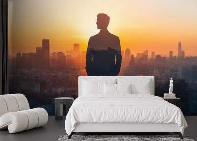 Entrepreneur standing on rooftop merging with city below close up, focus on, copy space as the sun sets Double exposure silhouette with sprawling cityscape Wall mural