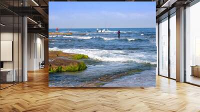 Fishermen catch fish on the Mediterranean coast at low tide Wall mural