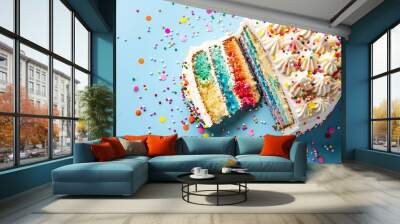 Sliced confetti birthday cake with rainbow colored icing and sprinkles over a blue background Wall mural