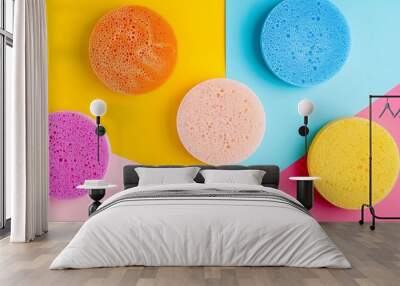 Spongy round flat items of different colours isolated on colorful background Wall mural