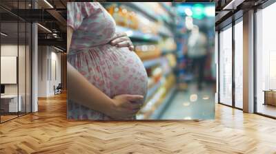 a pregnant woman holding her belly and shopping for baby products Wall mural