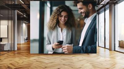 Cheerful and smiling young successful female businesswoman and man standing with a colleague Wall mural