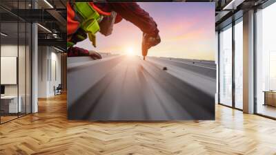 Close up shot roofing worker installing metal sheet roof on the construction site Wall mural