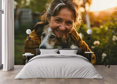 mature woman hugging her dog outside in her yard Wall mural